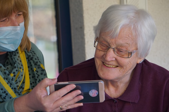 אישה מראה לקשישה סרטון בפלאפון
